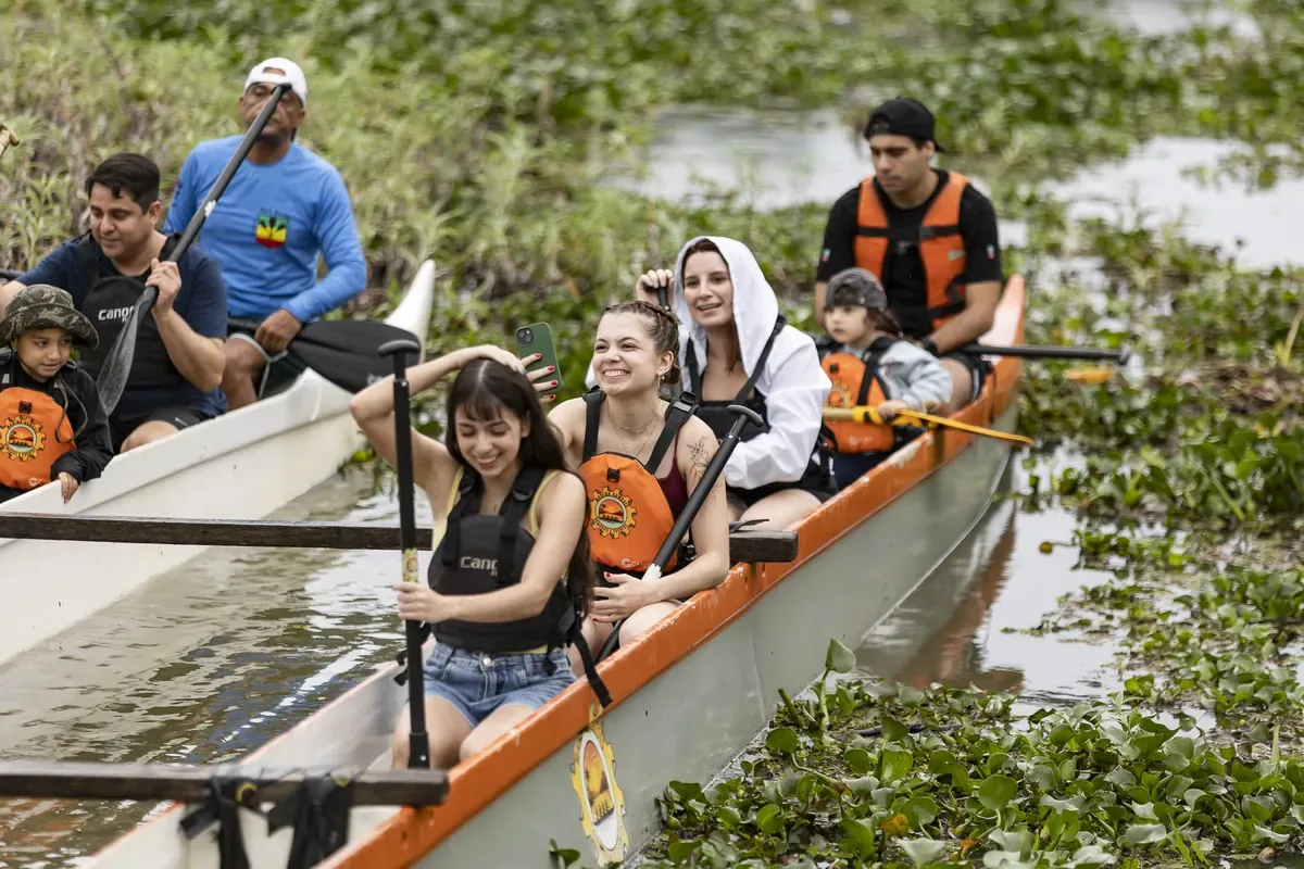 Atletas dentro da canoa, sorrindo